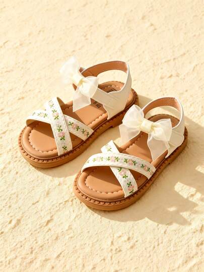 Sandal trẻ em gái 3-12 tuổi, màu kem và nâu nhạt, quai thêu hoa với nơ voan lớn, quai điều chỉnh được, kiểu công chúa nhỏ, thích hợp cho các bữa tiệc hàng ngày.