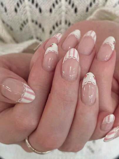 Bộ 10 móng giả ngắn hình hạnh nhân thủ công, màu nude, kiểu dáng nhẹ nhàng, tươi tắn, phong cách ngọt ngào dành cho các cô gái với ren trắng, sọc hồng và họa tiết hoa nhỏ, kèm theo dụng cụ làm móng, phù hợp cho cả phụ nữ và bé gái, dễ dàng đeo và tháo.