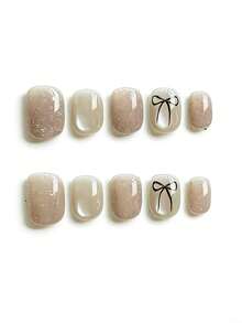 10pcs It Features An Elegant Palette Of Shimmering Nude Beige And Creamy Ivory, Adorned With Delicate Hand-Drawn Black Bow Motifs And Subtle Silver Glitter Accents, Exuding A Gentle And Sophisticated Vibe. The High-Shine Glossy Finish And Short Square Shape Create A Sleek, Versatile Daily Texture That Complements Any Outfit. Press On Nails - Apricot - View 1