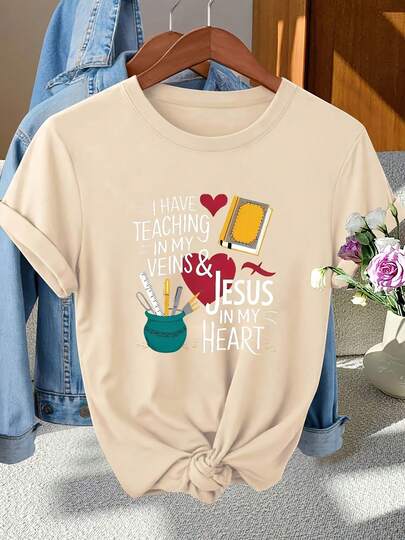 I Have Teaching In My Veins & Jesus In My Heart White Text Graphic Black T - Shirt With Teal Container Pens Fork Yellow Book Red Heart Design, Light Blue Denim Jacket Wooden Hanger Gray Surface, White Vase Pink White Flowers Wooden Surface Window Background - Casual Loose Fit T - Shirt For Daily Wear