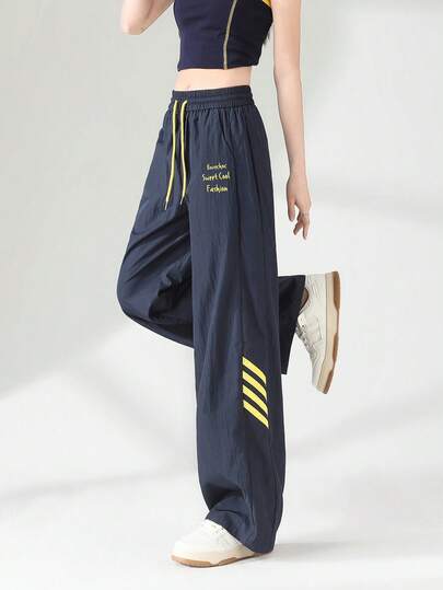 Pantalon droit à cordon de serrage avec poches latérales rayées bleu marine et jaune, coupe ample, convient pour le printemps, l'été et l'automne. Pantalon large à imprimé graphique anglais décontracté pour femmes, polyvalent pour le port en extérieur.