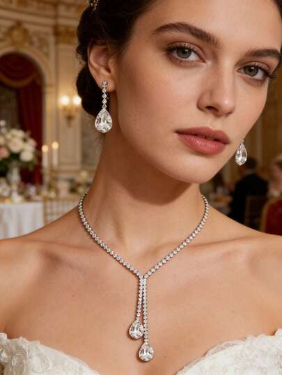 Bộ trang sức gồm 2 món mặt dây chuyền hình giọt nước đôi đơn giản, một hàng đá quý, thiết kế đế bạc, phù hợp với váy cưới/các dịp trang trọng. Bộ dây chuyền và bông tai bắt mắt.