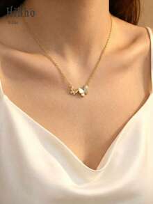 Hihho 一条镶嵌闪亮锆石的金色蝴蝶项链，一半由光泽柔和的珍珠母贝制成，一半镶满钻石，设计优雅灵动，是一款百搭的锁骨链，为您的整体造型增添一抹精致。 - 蝴蝶 - 查看 5