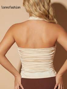 blusa asimetrica elegante de cuello halter cruzado para mujer , confeccionado en licra satinada stretch de alta calidad con textura sedosa, brillo sutil y ajuste perfecto que realza la figura; escote drapeado cruzado con frunces suaves que aportan un toque femenino y sofisticado, complementado con un herraje dorado central que añade distinción y elegancia; diseño con pliegues laterales que estilizan la cintura y crean una silueta armónica; espalda descubierta tipo strapless con acabado limpio - Champán - Ver 8
