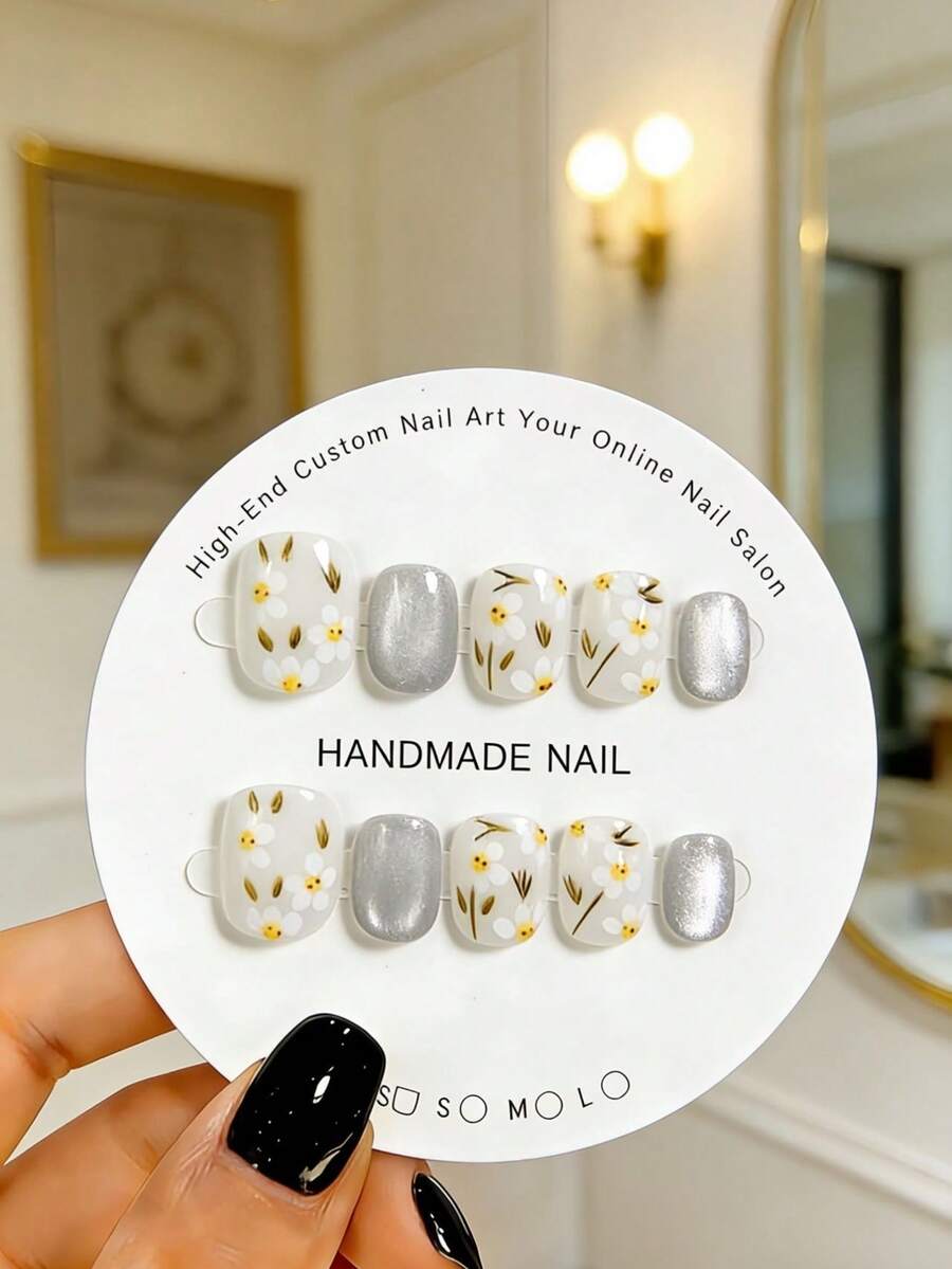 Bộ 10 miếng dán móng tay hình bầu dục ngắn thủ công, được vẽ tay họa tiết hoa nhí trang trí bằng những chiếc lá màu vàng xanh mảnh mai. Những miếng dán móng tay xinh xắn này phù hợp cho cả phụ nữ và bé gái, hoàn hảo cho các bữa tiệc, đám cưới và sử dụng hàng ngày, kèm theo bộ dụng cụ. - trắng - Xem 1