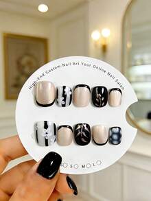 10 pièces d'autocollants d'ongles ovales courts faits à la main. Caractéristiques incluant des pointes françaises noires avec des rayures verticales noires épaisses, de petites fleurs blanches peintes à la main, des lignes en or rose et un effet œil de chat nude. Ces beaux autocollants pour ongles conviennent aux femmes et aux filles, parfaits pour les fêtes, les mariages et le port quotidien, livrés avec un kit d'outils. - Multicolore - Voir 10