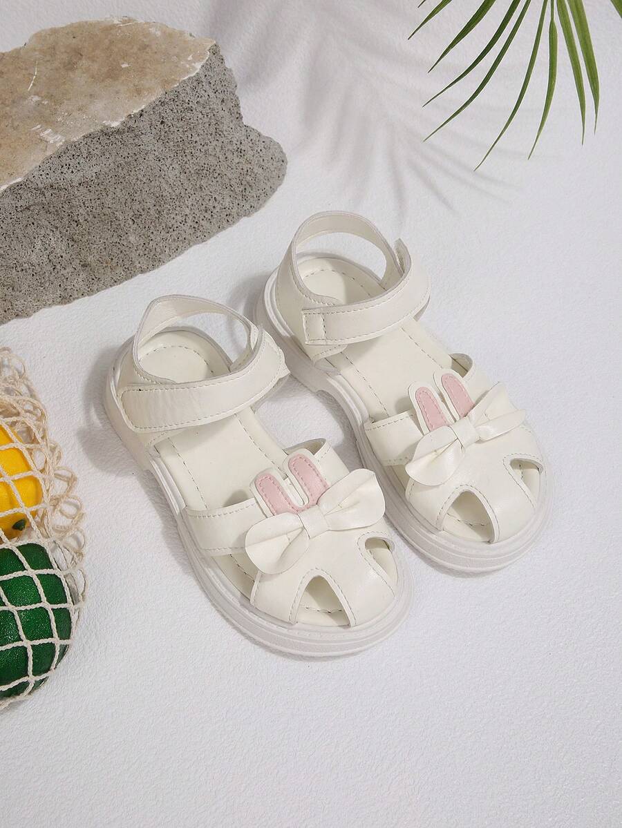 Giày sandal mới năm 2026 cho bé gái, giày mùa hè đế mềm kín mũi cho trẻ em, giày công chúa hình thỏ hoạt hình dễ thương có nơ, giày tập đi mùa hè đa năng đế mềm có khóa dán cho bé gái.