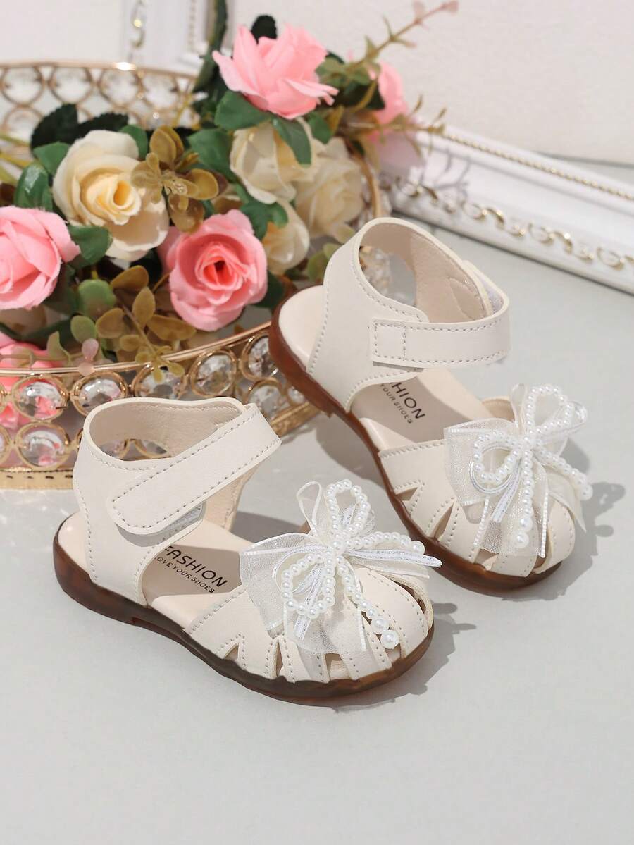 1 đôi dép xăng đan cho bé gái, giày công chúa đính nơ ngọc trai mùa hè mới cho trẻ em, giày tập đi đế mềm chống trơn trượt cho trẻ nhỏ. - Màu be - Xem 1
