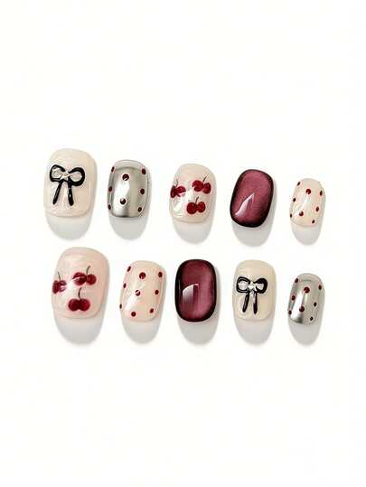 Bộ 10 móng giả này có bảng màu retro vui tươi với tông màu trắng kem, đỏ tía đậm với hiệu ứng mắt mèo như thủy tinh và bạc ánh kim, được trang trí bằng họa tiết quả anh đào vẽ tay, điểm nhấn chấm bi đỏ đen cổ điển và thiết kế nơ đen tinh tế với chi tiết đá lấp lánh.