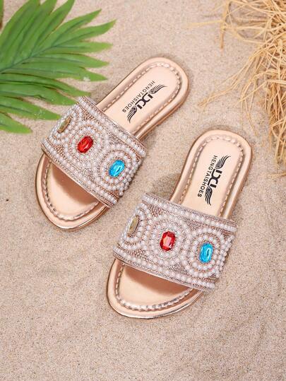 1 đôi sandal đế bằng phong cách Bohemian đính ngọc trai và đá giả kim cương nhiều màu sắc cùng điểm nhấn vàng.