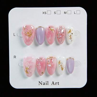 10片手工制作的杏仁形按压式假指甲（可佩戴），既是美甲用品又是装饰品。这些美丽的指甲采用柔和的粉色渐变底色，搭配玫瑰金线条，并点缀着金色箔片。它们可以修饰手型，提亮手部轮廓。套装包含使用工具，包括凝胶胶水和指甲锉，指甲可重复使用，且易于快速卸除。