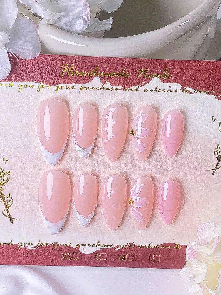 10 móng giả hình hạnh nhân thủ công màu trắng, kiểu Pháp, điểm xuyết chấm bi hồng, ngọc trai, hoa ba cánh hồng, hạt thép mạ vàng và hiệu ứng ombre sọc hồng. Hoàn hảo cho các bữa tiệc, buổi hẹn hò lãng mạn, và có thể được gắn và gỡ bỏ nhanh chóng bằng hệ thống dán móng nghệ thuật. Móng giả dán - Hồng - Xem 1