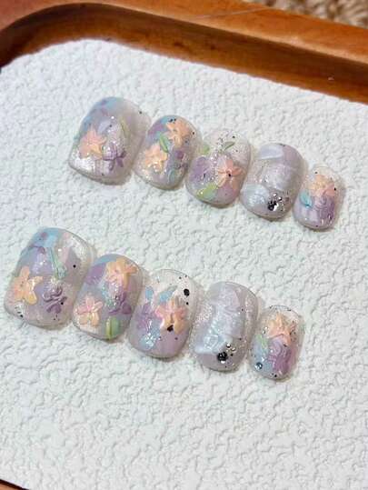 El yapımı takma tırnaklar, rüya gibi lavanta rengi tabanlı kısa kare takma tırnaklar, elle boyanmış 3 boyutlu renkli çiçekler, parlak gümüş sim ve yapay elmas detaylar, kadınlar için tatlı estetik yeniden kullanılabilir takma tırnak uçları, sevimli Y2K Kore tarzı manikür seti, parlak yüzeyli yapay tırnaklar günlük kullanım, randevu, parti, festival, tatil ve hediye için mükemmeldir.