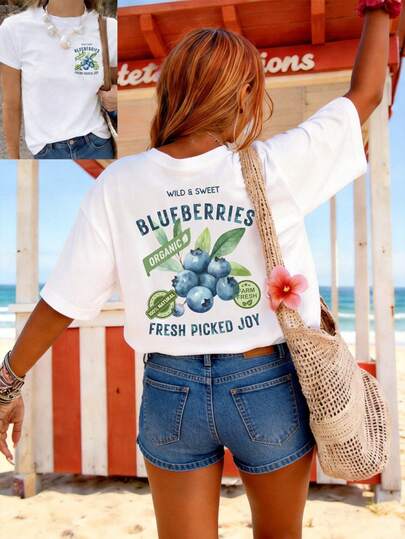 女士春夏服装：双面印花T恤，采用水彩风格的蓝莓和叶子图案，并印有“野生甜蓝莓有机”字样。休闲日常穿着，短袖圆领设计。