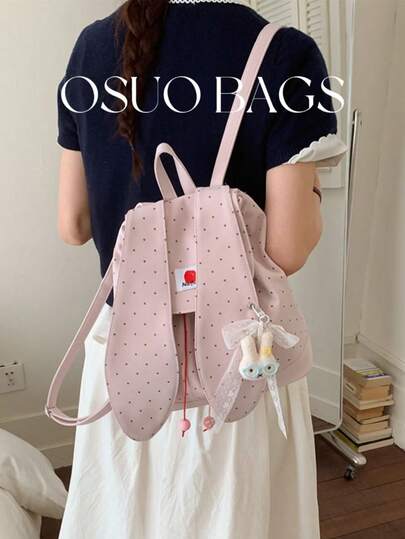 1 chiếc balo nữ bằng nylon màu trơn, thiết kế chấm bi thời trang, kiểu dáng túi xách có nắp gập và dây rút, phong cách sinh viên với trang trí xếp ly và điểm nhấn nơ hoạt hình, phù hợp cho sinh viên đi du lịch, đi làm và sinh hoạt trong khuôn viên trường.