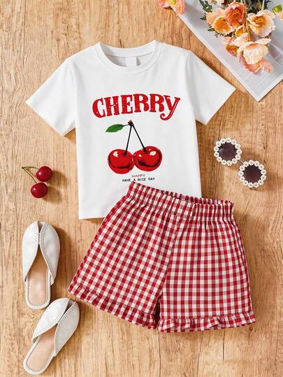 Bộ đồ 2 món gồm áo thun cổ tròn in hình quả anh đào và chữ cái, quần short kẻ caro đỏ, trang phục mùa hè thoải mái cho các cô gái tuổi teen.
