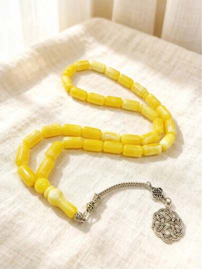 Chuỗi 33 hạt hình bầu dục nhẵn mịn, tạo nên kết cấu tinh tế như đá, kết hợp với mặt dây chuyền bằng tre và dây tua rua màu xanh lá cây. Thiết kế đơn giản nhưng hài hòa, nhẹ nhàng và thoải mái, phù hợp để đeo hàng ngày hoặc thiền định, kết hợp vẻ đẹp thanh tịnh và sức mạnh của niềm tin.