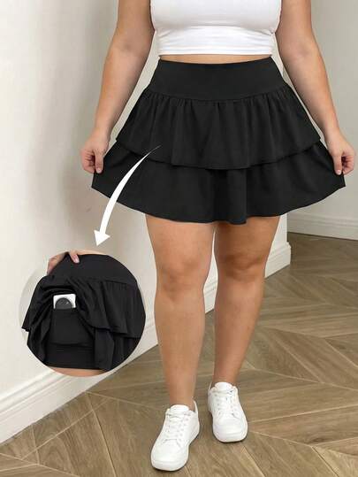 Chân váy ngắn chữ A màu đen cỡ lớn dành cho nữ, thiết kế xếp lớp, có đai an toàn bên hông, túi hai bên, phù hợp với dáng người quả táo.