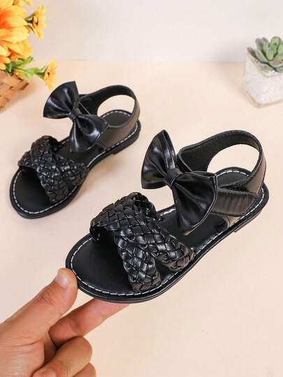 1 đôi dép xăng đan đế bằng màu đen cho bé gái, quai chéo đan bằng da PU với nơ trang trí, thiết kế một quai, mũi tròn, chống trơn trượt, nhẹ, kiểu dép La Mã giản dị và dễ thương, phù hợp cho bé gái từ 3-15 tuổi, dùng hàng ngày, dự tiệc, đi nghỉ mát, mẫu mới mùa xuân/thu.