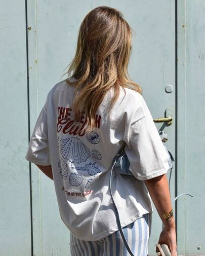 Women's Y2K Aesthetic "The Beach Club" Seashell Graphic Oversized T Shirt, Casual Streetwear Short Sleeve Crew Neck Tee, Vintage Nautical Coastal Printed Top, Summer Beach Vacation Outfit, Daily Wear, Coffee Date, Party, Holiday Fashion for Teen Girls, Trendy Loose Graphic Tee for Young Women & Beach Lovers