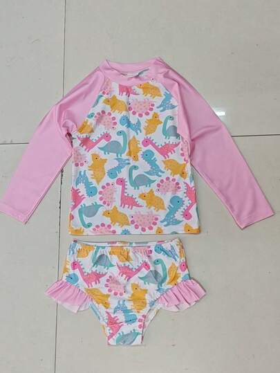 Bộ đồ bơi chống nắng cho bé gái: Áo chống nắng tay dài in hình khủng long hoạt hình màu pastel (hồng, xanh dương, vàng) + viền chấm bi hồng dễ thương, thiết kế khủng long mềm mại hoàn hảo cho bé gái, đầy vẻ đáng yêu trẻ thơ. Quần: Quần bikini viền bèo nhún, thích hợp cho bãi biển, hồ bơi và các hoạt động dưới nước hàng ngày.