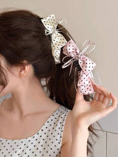 1 chiếc kẹp tóc hình nơ chấm bi bằng satin, kiểu dáng ngọt ngào, dịu dàng, thích hợp cho kiểu tóc đuôi ngựa cao.
