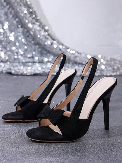 1双女士黑色露跟高跟凉鞋，经典蝴蝶结装饰细高跟，优雅拉长腿部线条，适合派对、宴会、约会等场合。