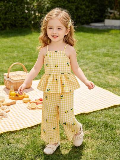 这款女童黄色格子柠檬印花清新度假风套装，包含一件无袖娃娃衫和一条阔腿裤。黄白格子底布上点缀着活力四射的柠檬印花，宽松的娃娃衫采用收腰设计，适合度假、海滩漫步、公园散步、周末购物等各种场合。