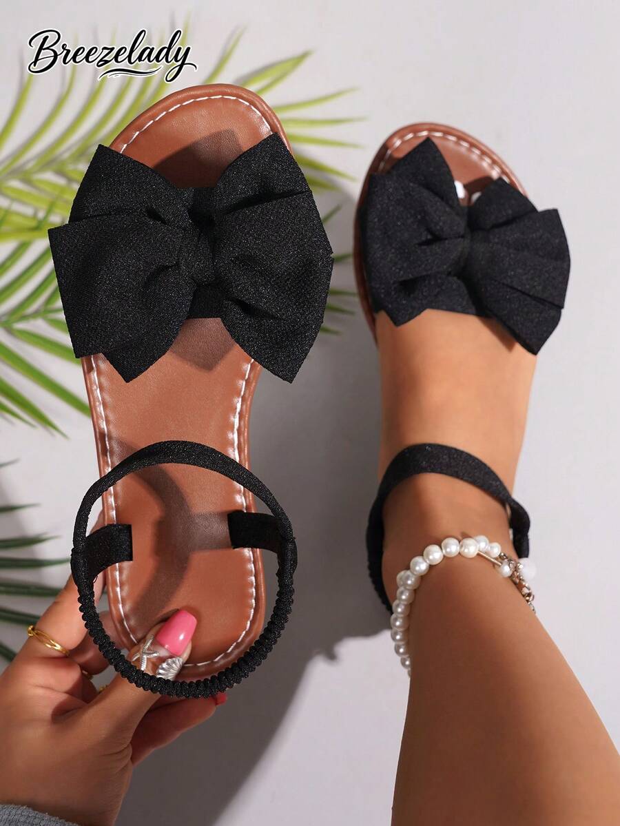 Breezelady Women's Black Bow Flat Sandals – Chic Casual Style, Large Fabric Bow Accent, Adjustable Ankle Strap For Custom Fit, Soft Cushioned Footbed & Durable Sole For All-Day Comfort. Crafted With Breathable Textile Material, These Sandals Blend Sweet Charm With Everyday Practicality. Perfect For Summer Outings: Pair With Denim Shorts For A Relaxed Weekend Look, Match With Sundresses For Brunch Dates, Or Style With Midi Skirts For A Cute Casual Vibe. Ideal For College Students, Office Workers (For Casual Fridays), And Fashion Women Who Love Effortless, Eye-Catching Footwear. Lightweight & Versatile: The Open-Toe Design Keeps Feet Cool In Warm Weather, While The Minimalist Silhouette Ensures Easy Pairing With Any Summer Wardrobe. Whether You're Running Errands, Meeting Friends, Or Exploring A New City, These Sandals Offer Both Style And Comfort. A Must-Have Addition To Your Summer Shoe Collection – Equal Parts Adorable And Functional! - màu đen - Xem 1
