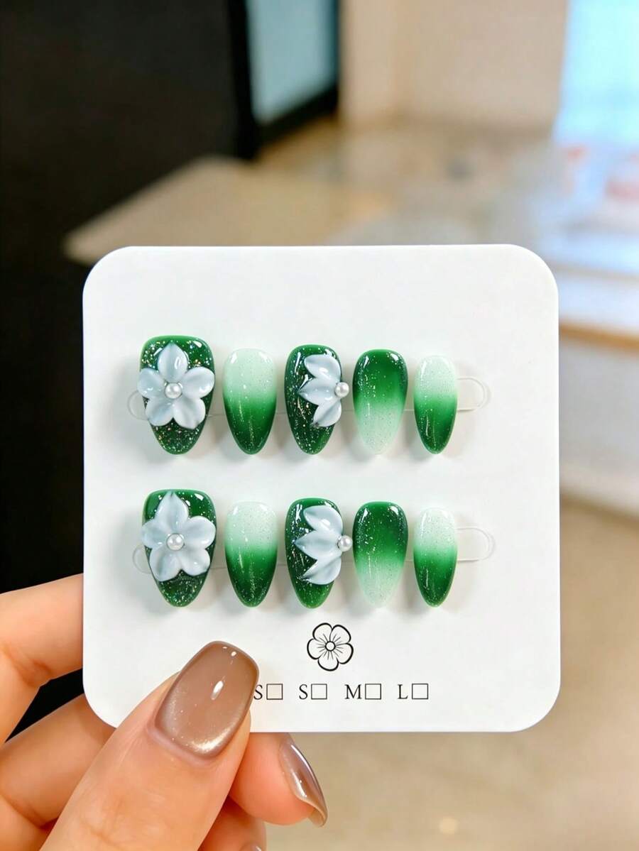 10片手工制作的杏仁形绿色假指甲，饰有白色雕刻图案和银色闪粉，极其精美，可重复使用，易于快速卸除，点缀白色珍珠，适合派对、婚礼和日常佩戴，附赠美甲工具套装，是送给女性和女孩的完美礼物。 - 綠色 - 查看 1