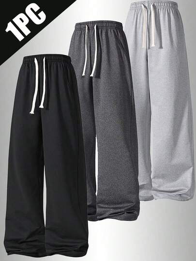 1件男士宽松休闲运动裤，采用简约纯色阔腿设计，配有抽绳腰带和大口袋，适合日常行走、工作、旅行和其他场合。