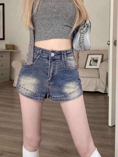 Quần short nữ dáng suông denim wash vintage, cài nút và khóa kéo, chất liệu co giãn, phù hợp với trang phục mùa hè thoải mái.