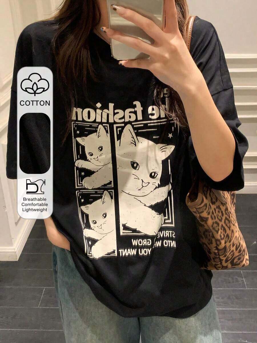 Camiseta de Mujer Holgada y Moderna con Diseño de Gato de Dibujos Animados, Tipografía Retro "The Fashion" con Diseño de Tres Gatitos Blancos, Transpirable y Cómoda, Manga Corta, 100% Algodón, Cuello Redondo, Ideal para Salidas Casuales y Looks de Moda con Animales Adorables - Negro - Ver 1