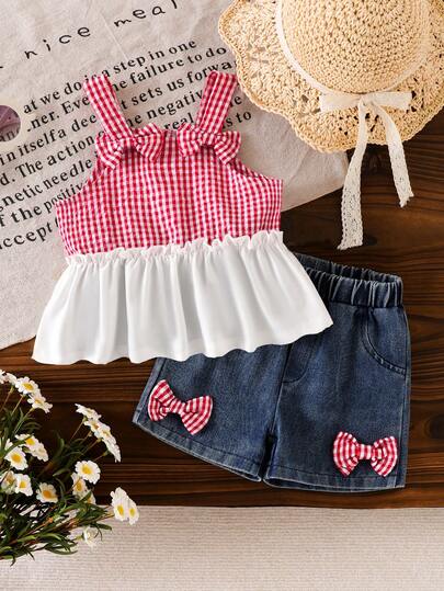 Bộ 2 món cho bé gái phong cách đồng quê, họa tiết kẻ caro phối màu tương phản, viền bèo nhún, không tay, trang trí nơ 3D, gồm áo hai dây và quần short denim nơ 3D.