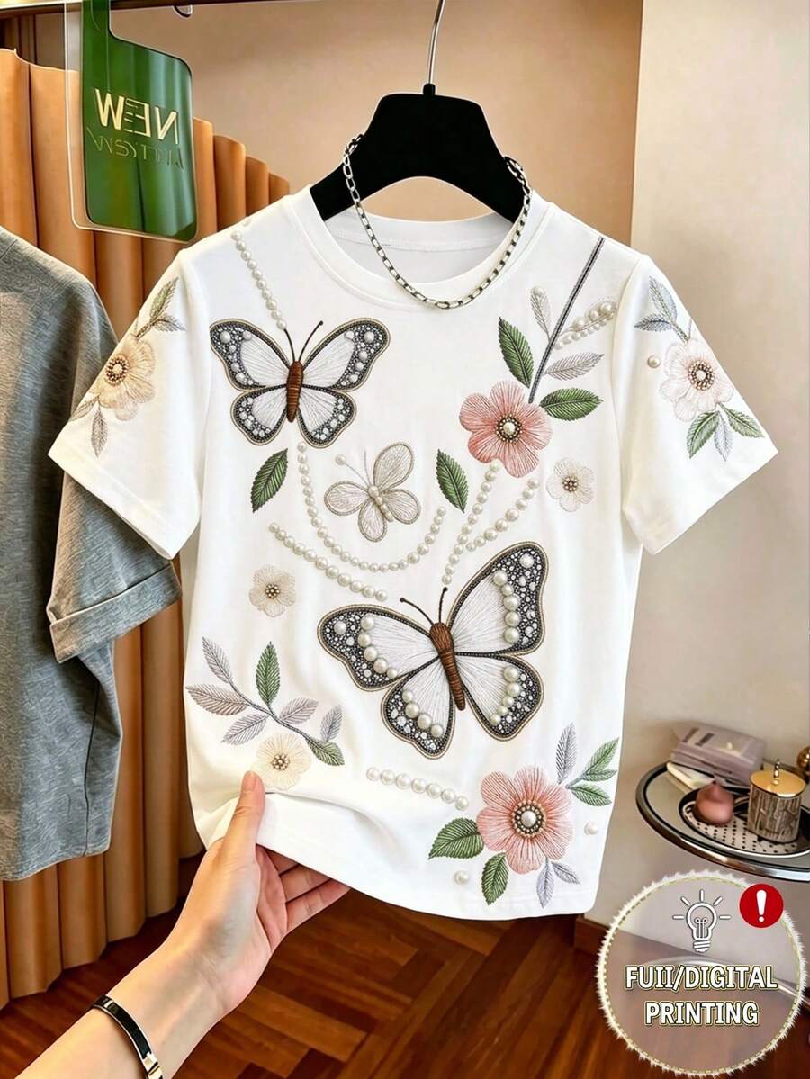 Áo thun nữ dáng rộng, thanh lịch, cổ tròn, in hình bướm và hoa đính ngọc trai, kiểu dáng giản dị và đa năng, phù hợp cho các hoạt động hàng ngày, đi làm, họp mặt ngày lễ, hẹn hò, công sở, mua sắm đường phố, du lịch, kỳ nghỉ và các dịp khác. Áo thun in hình dành cho nữ, áo thun ngắn tay hàng ngày, áo thun dệt kim, áo thun mùa hè cho nữ, trang phục cần thiết cho mùa hè, ngày lễ tình nhân. - Nhiều màu - Xem 1
