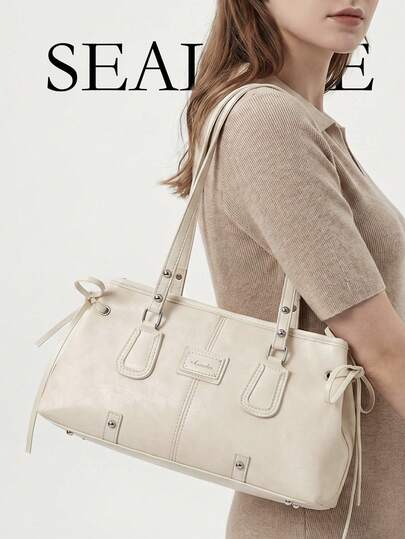 时尚现代风格女士单肩手提包；白色PU皮革材质，休闲法棍包造型，侧边抽绳配蝴蝶结设计，包身饰有铆钉，并带有品牌标签。适合日常使用，例如购物。