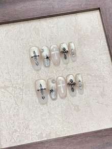 Bộ 10 móng tay giả thủ công, hình bầu dục ngắn, kiểu dáng Y2K thập tự giá, màu trắng sữa với họa tiết mắt mèo lấp lánh, kết hợp với hình dán thập tự giá và đá đính rải rác, vừa cá tính vừa sành điệu, rất ăn ảnh, đa năng, phù hợp cho các lễ hội âm nhạc, tiệc tùng, hẹn hò và sử dụng hàng ngày. Bộ móng giả dán thủ công có thể tái sử dụng bao gồm một tờ keo dán và một dũa móng mini, phù hợp cho người mới bắt đầu sử dụng. - trắng - Xem 2