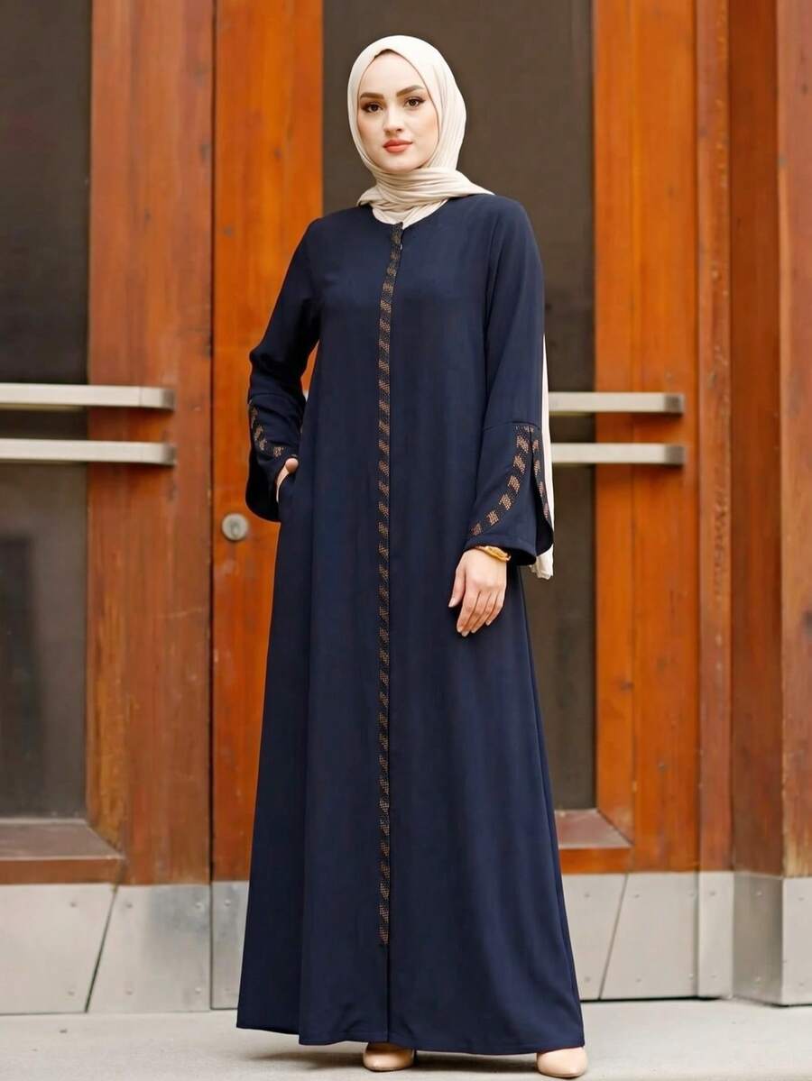 Abaya nera a maniche lunghe con collo tondo, in tessuto lavorato, con tasche con strisce dorate, per la primavera