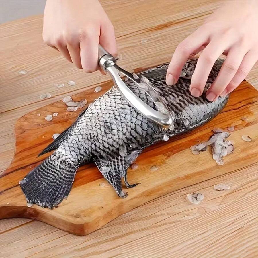 Raspador de escamas de pescado de acero inoxidable, con hoja dentada fina de doble cara, que elimina rápidamente las escamas de pescado sin salpicaduras ni dañar la piel. Construcción de una sola pieza de acero sólido, resistente a la oxidación, con mango largo antideslizante para un agarre fácil. Orificio para colgar para su almacenamiento, adecuado para el hogar, la cocina, el procesamiento de mariscos frescos, las cocinas de restaurantes y los entusiastas de la pesca para limpiar fácilmente los peces vivos.