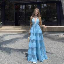 La mujer cuelga un vestido largo con una capa de pastel junto a una hoja de volantes de cuello V profundo. - Azul - Ver 3