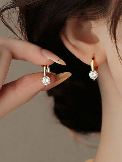 一对简约优雅的单钻耳环，适合日常或正式场合佩戴。