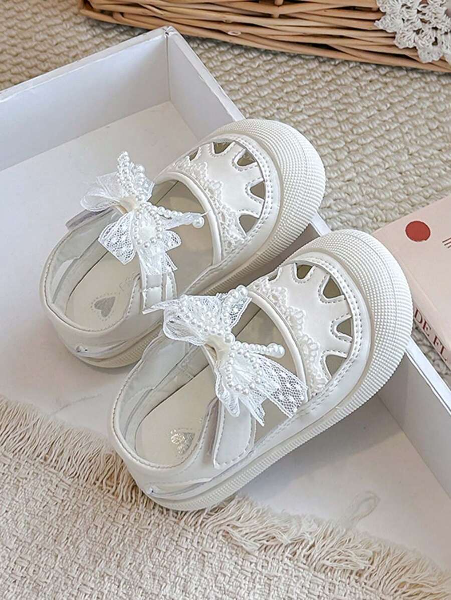 1 đôi sandal mùa hè thoáng khí cho bé gái, có nơ ngọc trai và dây buộc, đế mềm chống trơn trượt. - Màu be - Xem 1