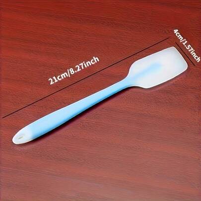 A Blue Silicone Scraper - A Non-Stick Kitchen Tool Suitable For Cooking And Baking, Made Of Material And Capable Of Being Washed In The Dishwasher, Falls Under The Categories Of Kitchen Accessories, Kitchen Tools, And Baking Supplies.