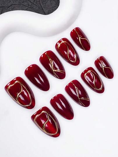 10 pièces d'ongles courts en forme d'amande, faits à la main. œil de chat bordeaux avec design de ligne dorée asymétrique, surface de luxe haute brillance. Convient pour les sorties, les galas et les occasions quotidiennes. Autocollants d'ongles réutilisables toute saison. Livré avec gel de gelée et lime à ongles. Fournitures de manucure DIY