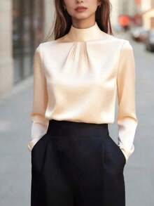 Blusa de mujer de satén negro, con cuello alto, mangas largas y pliegues en el pecho.Su textura satinada le da un aire elegante y versátil, perfecta para usar en la oficina, eventos formales o looks casuales, durante todo el año. - Albaricoque - Ver 2