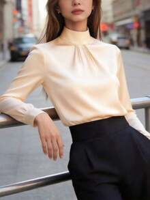 Blusa de mujer de satén negro, con cuello alto, mangas largas y pliegues en el pecho.Su textura satinada le da un aire elegante y versátil, perfecta para usar en la oficina, eventos formales o looks casuales, durante todo el año. - Albaricoque - Ver 4