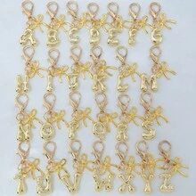 1个A-Z金色泡泡字母可爱吊坠，蝴蝶结装饰，钥匙扣，戒指托，背包挂饰，汽车挂饰，购物，海滩，露营，钱包配饰。适合作为礼物送给女性、朋友和学生，时尚创意设计，生日礼物装饰，圣诞礼物。送给母亲、父亲、毕业生和老师的礼物。 - 金色蝴蝶結 - 查看 9
