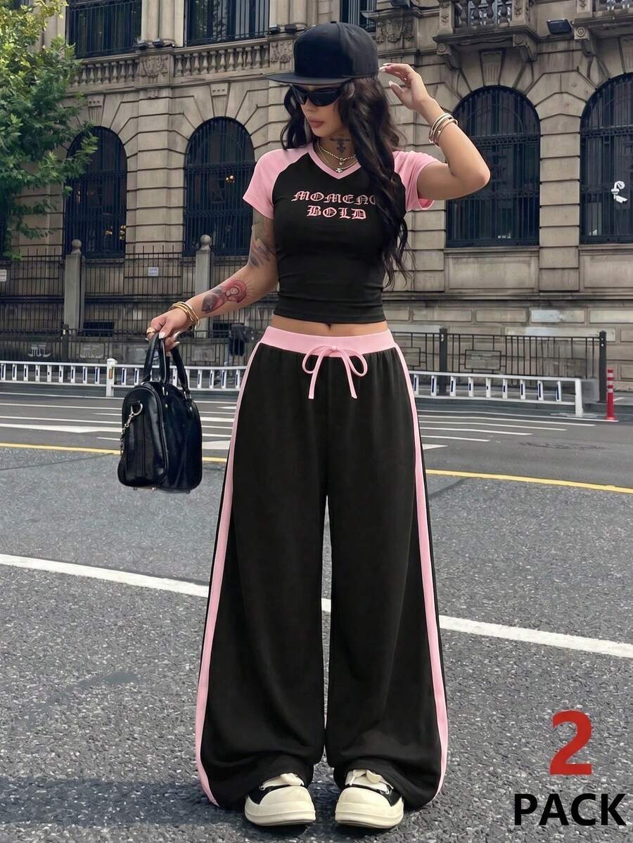 女士休闲两件套，黑色露脐上衣配粉色袖子，搭配同色系阔腿运动裤，适合夏季日常穿着。 - 黑色 - 查看 1