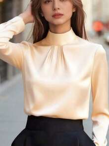 Blusa de mujer de satén negro, con cuello alto, mangas largas y pliegues en el pecho.Su textura satinada le da un aire elegante y versátil, perfecta para usar en la oficina, eventos formales o looks casuales, durante todo el año. - Albaricoque - Ver 5