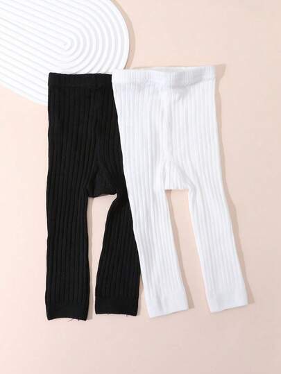 2 chiếc quần legging dài đến mắt cá chân cho bé, màu đen trắng, không có quai giữ chân, quần tất màu trơn.
